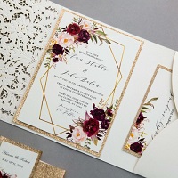 ivory laser cut pocket wedding invitations with floral pattern around framed wording EWDM009