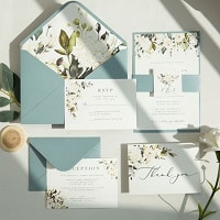 white blooms and greenery wedding invites with dusty blue paper backer and tag ewis010