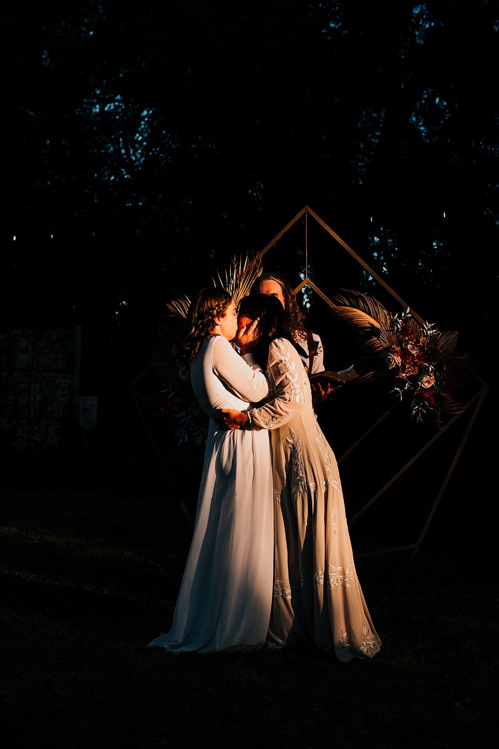 Two brides kissing at the end of their wedding ceremony