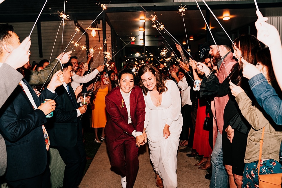 Dalawang bride ang tumatakbo sa isang tunnel ng sparklers sa isang wedding entrance song